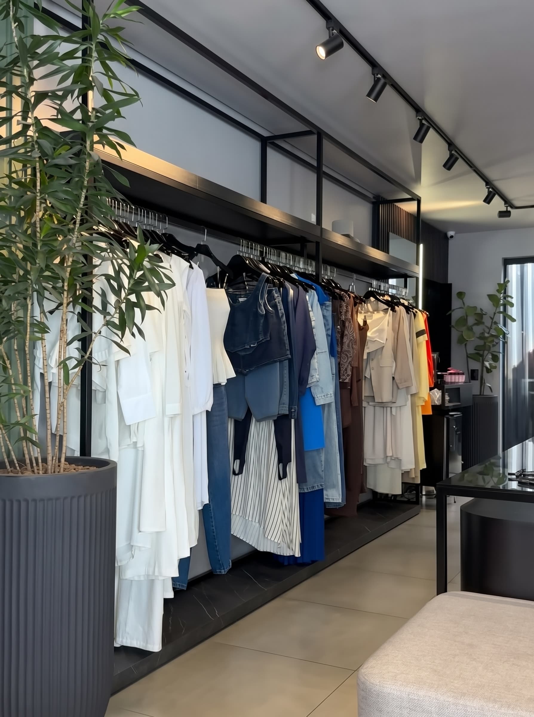 Interior da loja Lorraine Bernardes com araras de roupas